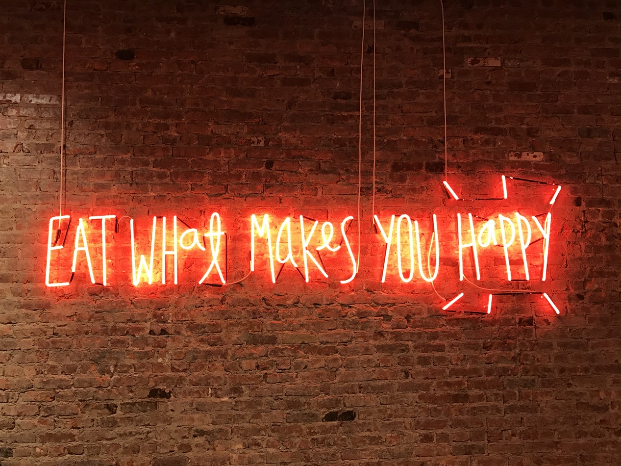 Neon sign reading Eat What Makes You Happy
