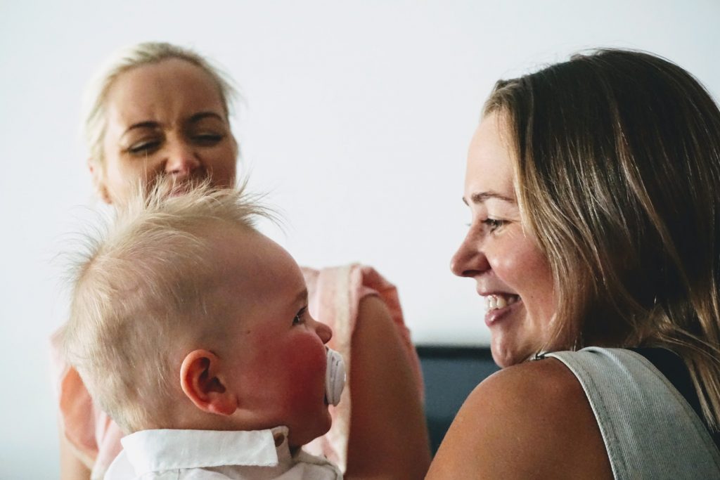 Jenna hugs her nephew, with her sister watching over