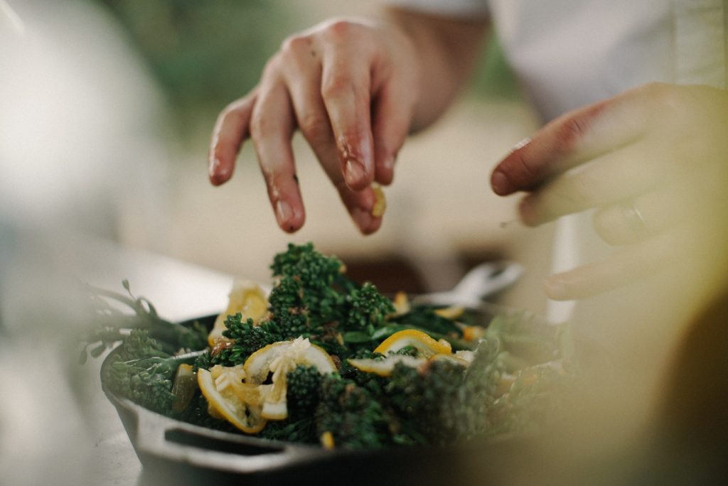 Prepping a green salad with olive oil