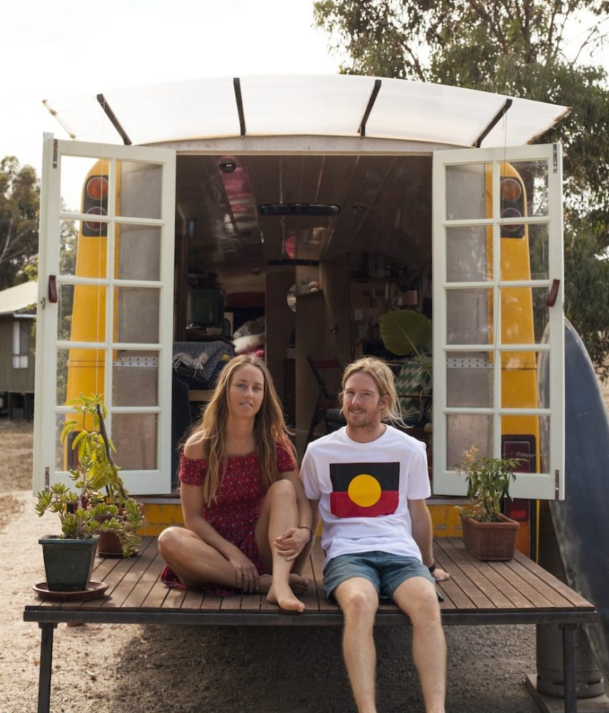 Emma and Felix sit on their rear decking at the back of their bus.