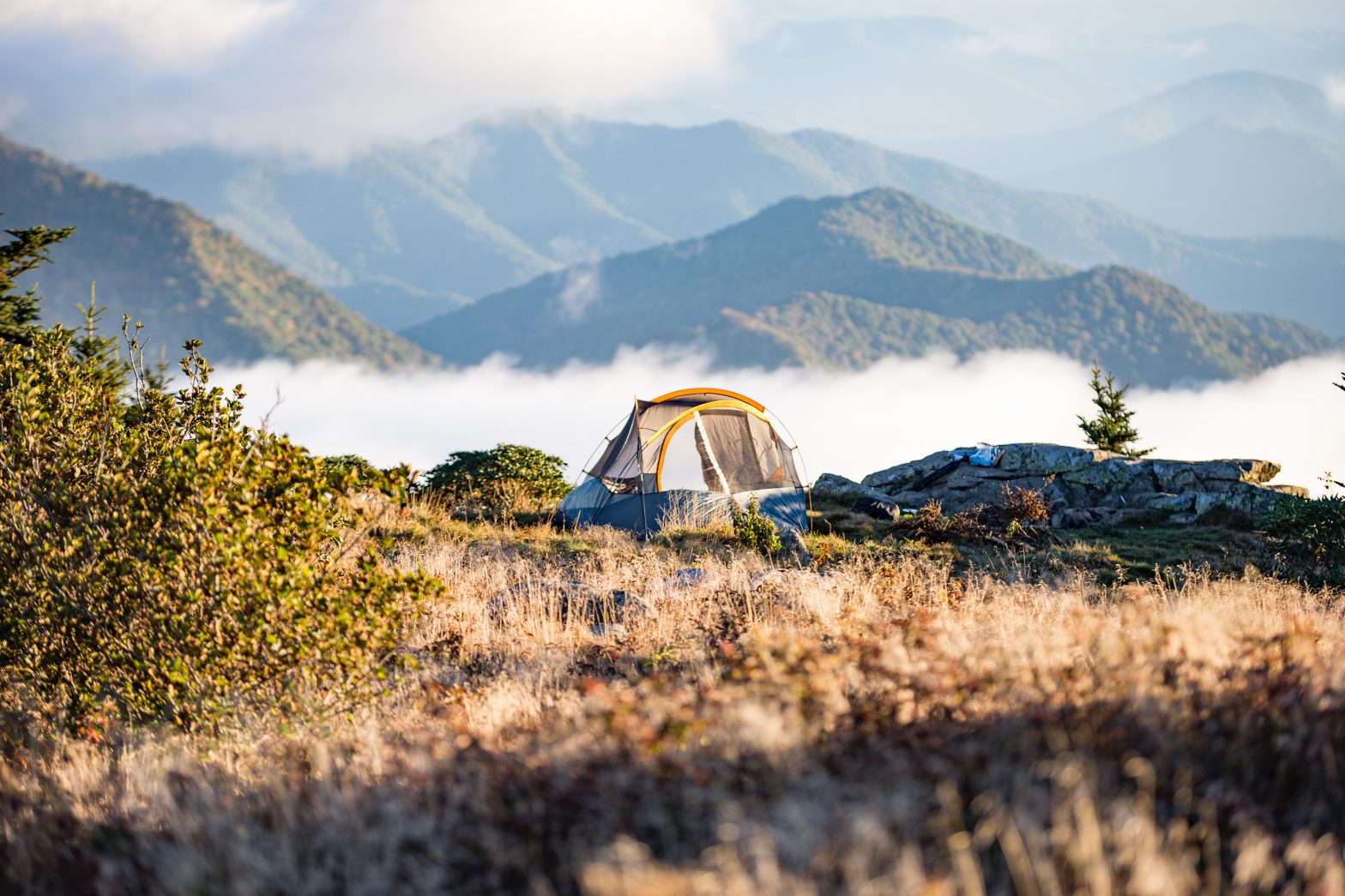 A tent is pitched on top of a mountain