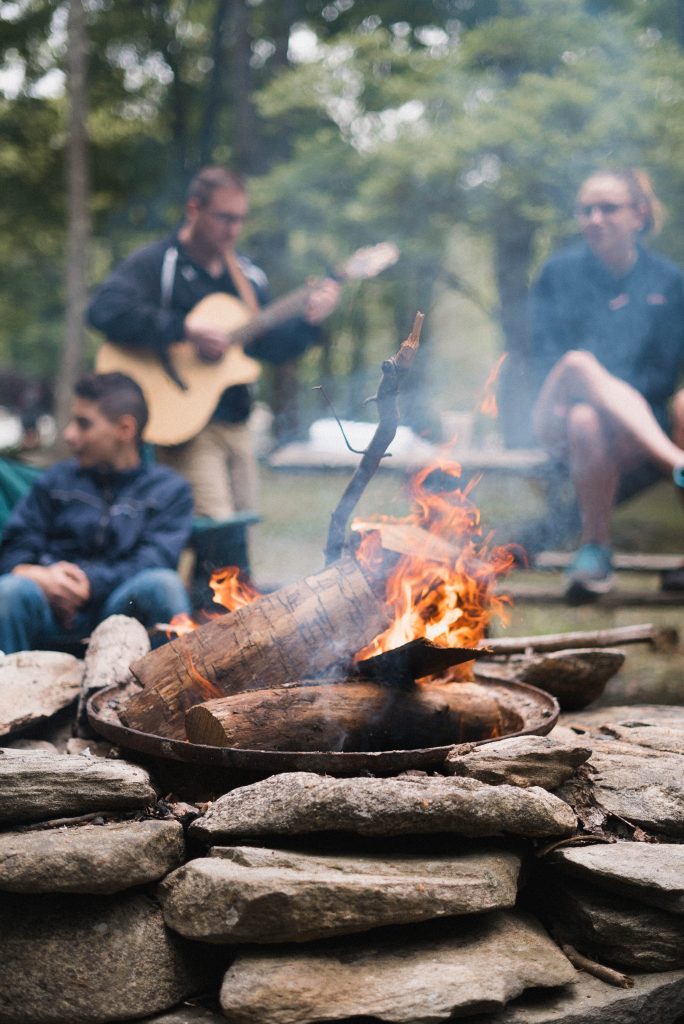 A group of friends play sitting around the campfire