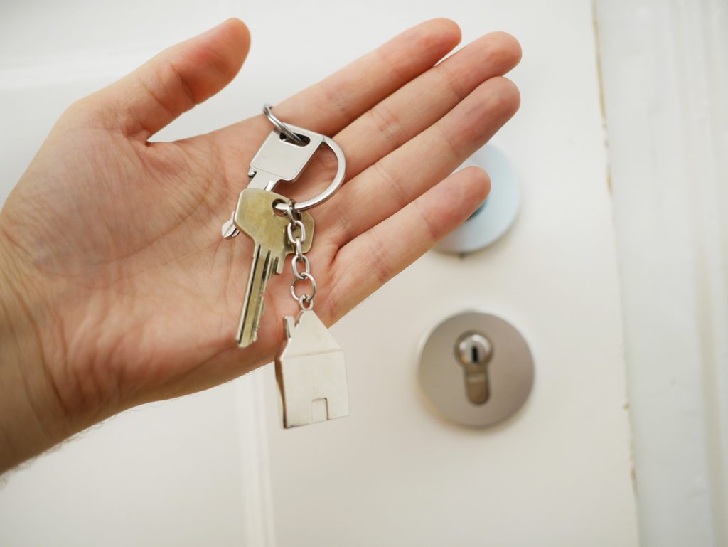 A hand holds a keychain with keys