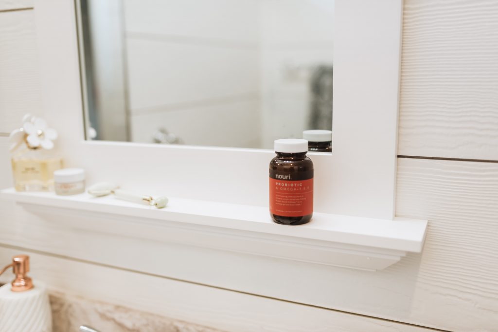 A jar of probiotics sits on a bathroom shelf