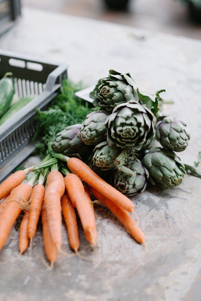 Carrots and vegetables sit on the bench awaiting chopping