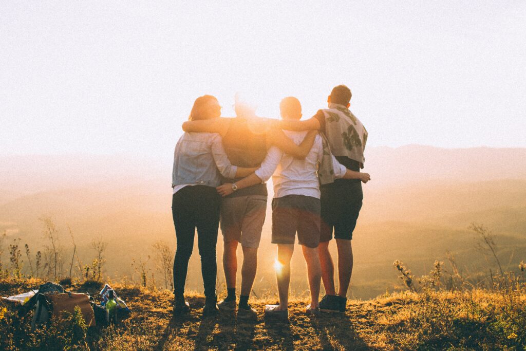 Four friends hugging in the sunset